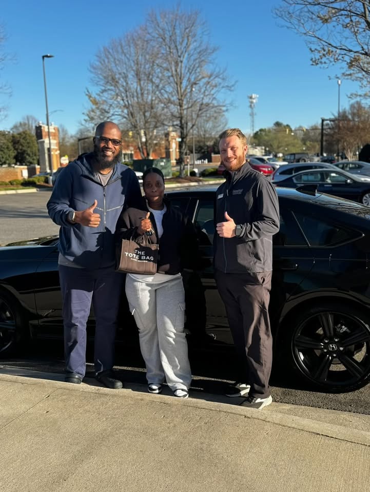 Luke Laliberte with clients next to their new Honda